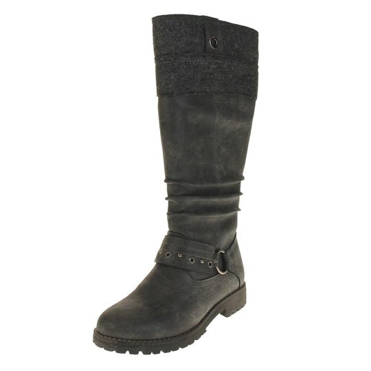 Grey suede boots knee high. Tall boots with a grey faux nubuck leather upper with a felt decorative cuff around the top. A strap with stud embellishment goes around the front of the ankle connected by a silver loop. Stitching detail around the outsole and the ankle. Full length zip to the inside leg. Left foot at an angle.