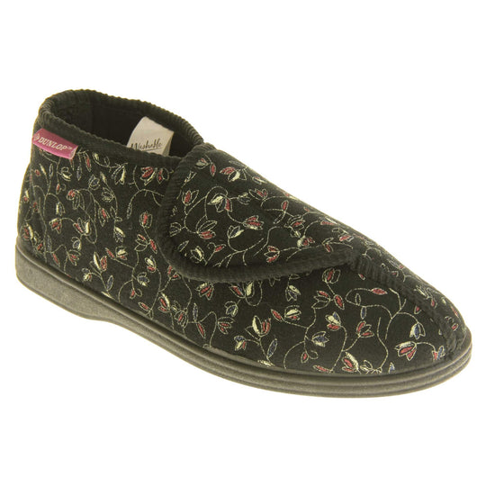 Hard sole slippers womens. Ladies bootie style slipper with a black textile upper with vine flower embroidered design. Touch fasten tab to the top and black textile lining. Firm black sole. Right foot at an angle.