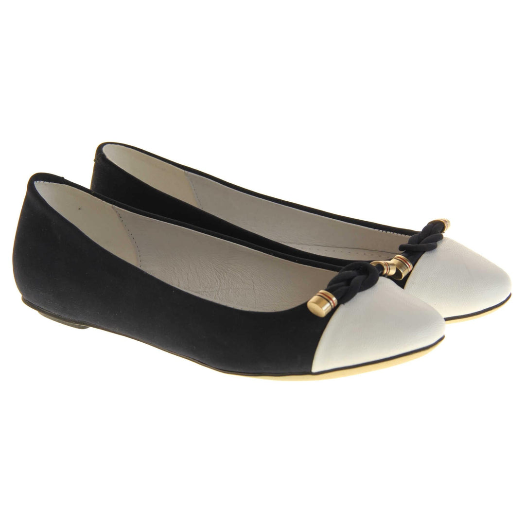 Blue white flat shoes. Womens ballet style shoes with a dark blue faux suede upper with white toe. Braided rope detail to the top with gold studs to the end. White real leather lining and black sole. Both feet together at a slight angle.