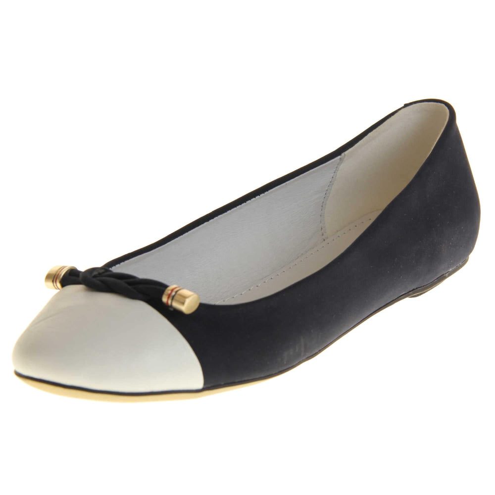 Blue white flat shoes. Womens ballet style shoes with a dark blue faux suede upper with white toe. Braided rope detail to the top with gold studs to the end. White real leather lining and black sole. Left foot at an angle.