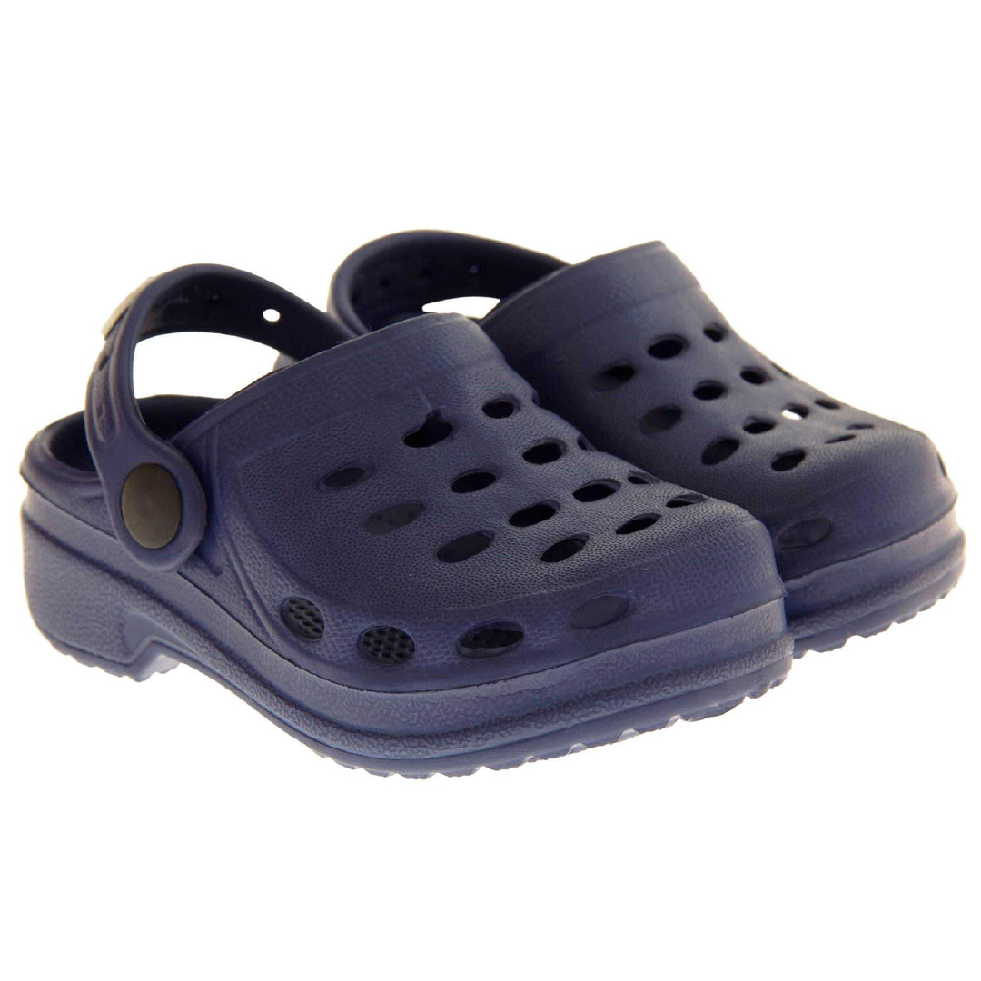 Kids Pool Shoes. Navy Blue synthetic clog style shoes. Cut out holes around the toes and the upper. Navy strap that goes along the back of your heel. The strap can be moved along the top of the shoe instead to make the shoe a mule. Both shoes next to each other at a slight angle.