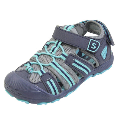 Kids beach sandals. Strappy beach sandals with grey mesh and navy faux leather uppers. with turquoise and navy textile strap detailing. Turquoise elasticated faux laces to the front. Navy faux leather straps around the front and back of the ankle with touch fastening. Turquoise insole. Navy rubbery outsole and toe bumper with turquoise and navy grip on the bottom. Left foot at an angle.