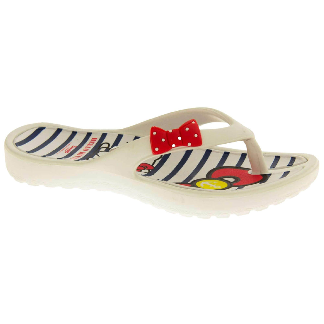 Kids flip flop. Hello Kitty flip flop with white sole and straps in a toe-post design with small red bow with white spots on. White and navy striped insole with Hello Kitty design on. Right foot at a slight angle.