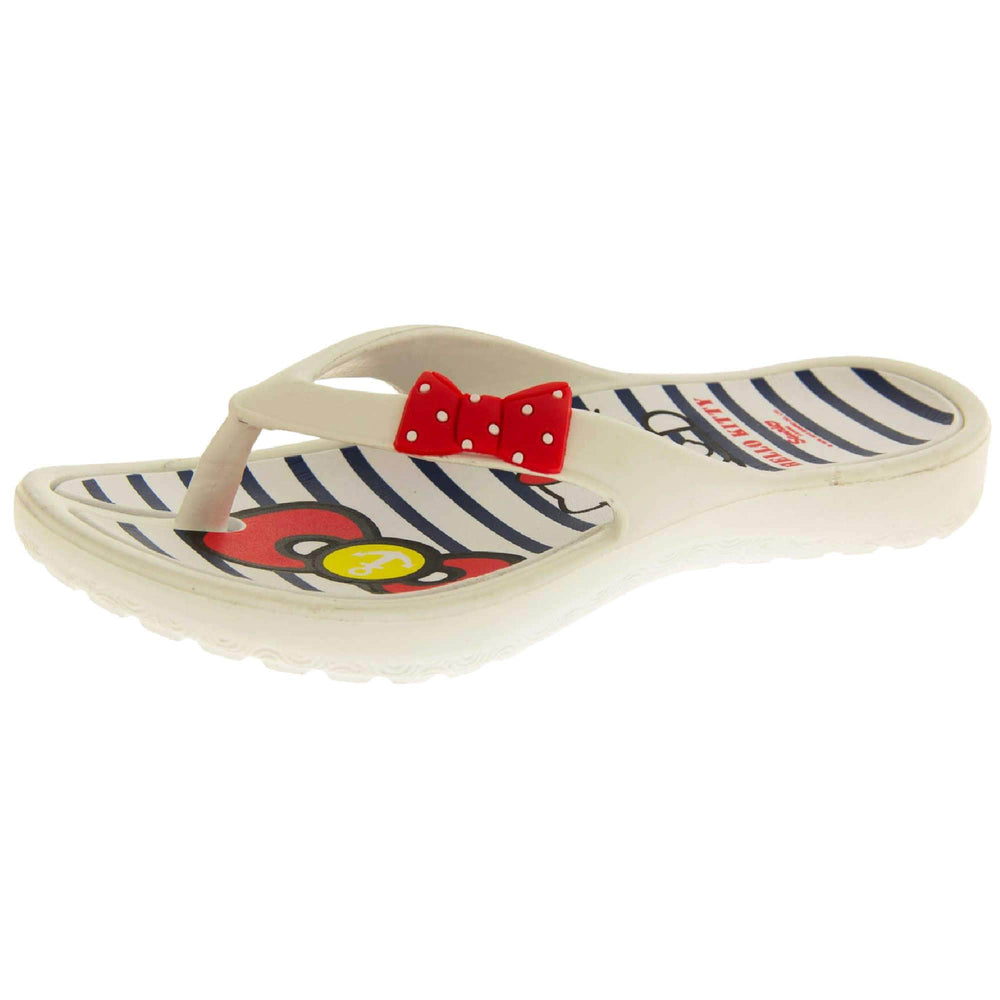 Kids flip flop. Hello Kitty flip flop with white sole and straps in a toe-post design with small red bow with white spots on. White and navy striped insole with Hello Kitty design on. Left foot at a slight angle.