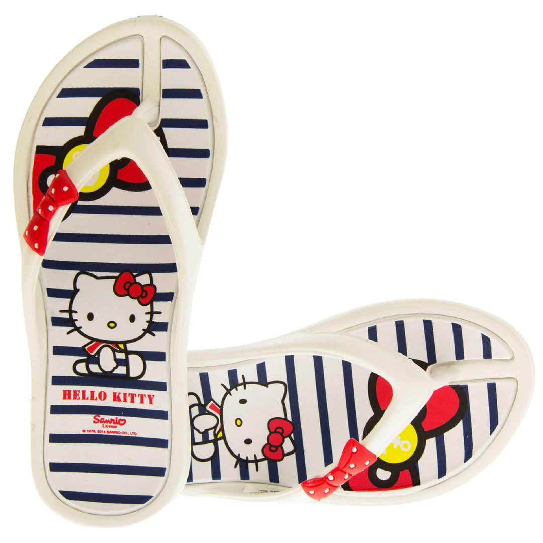 Kids flip flop. Hello Kitty flip flop with white sole and straps in a toe-post design with small red bow with white spots on. White and navy striped insole with Hello Kitty design on.  Both feet from a birds eye view with the shoes in an L shape.