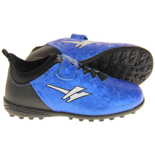 Kids football trainers. Metallic cerulean blue Gola boots with white Gola logo to the sides. With black heel and tongue and black elastic lace detail to the front. Metallic blue touch close strap with Gola branding across it. Black soles with small Astroturf studs. Both feet from side profile with the left foot on its side to show the base of the shoe.