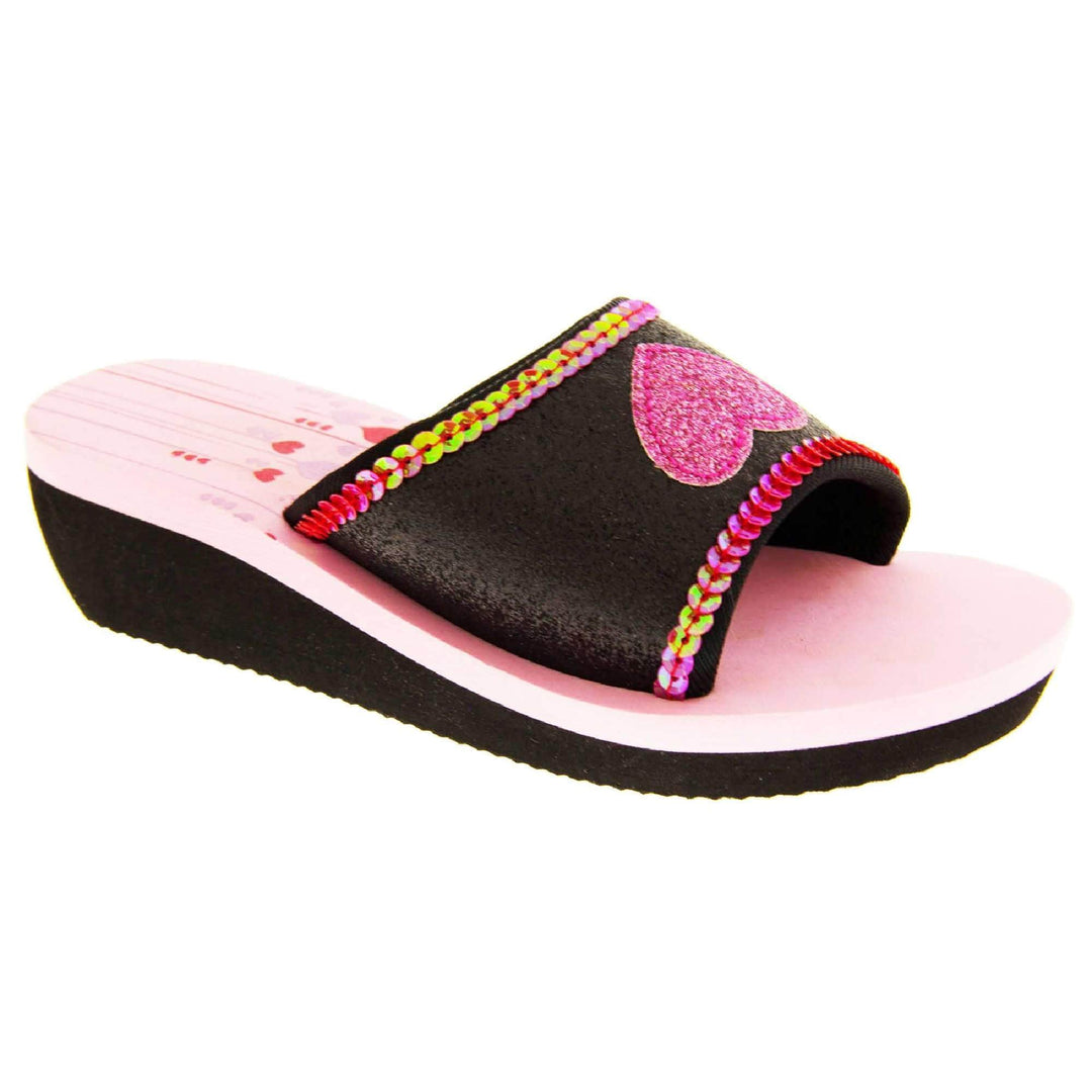 Foam wedge sandals for girls. Black bottom half of the sole with ridges for grip, baby pink top half with red and pale pink heart and line design to the heel of the insole. Black glitter full strap with bright pink glitter heart in the middle and pink sequins along the edges. Right foot at an angle.