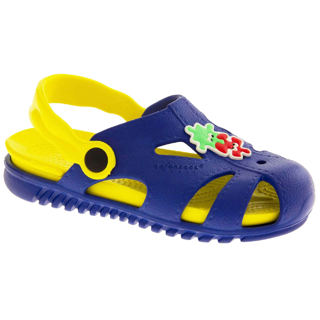 Kids pool clogs. Fisherman style synthetic sandals with blue upper and outer sole. Yellow ankle strap and insole. Green and red jigsaw pieces detail to the centre of the upper. Right foot at an angle.