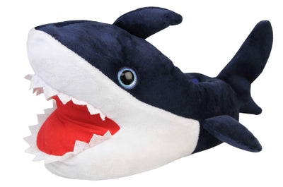 Kids shark slippers. Padded slippers in the shape of a shark with its mouth open. Blue upper and tail and white mouth and belly. Mouth is red felt with white felt shark teeth around the edge. Blue false eyes. Left foot at an angle.