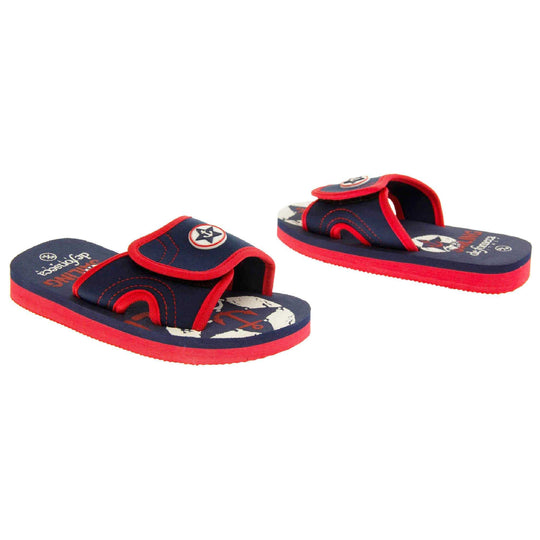 Kids sliders. Slip on slider style sandals. Navy blue touch fasten strap with red around the edge and a white synthetic circle in the centre of the strap with navy anchor in the middle. The foam sole is two toned. The top half is navy, the bottom half is red. Both shoes at a slight angle facing top to tail.
