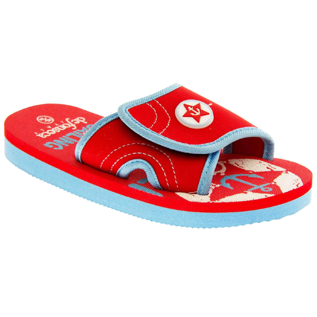 Kids slip on sandals. Slip on slider style sandals. Red touch fasten strap with light blue around the edge and a white synthetic circle in the centre of the strap with red anchor in the middle. The foam sole is two toned. The top half is red, the bottom half is pale blue. Right foot at an angle.