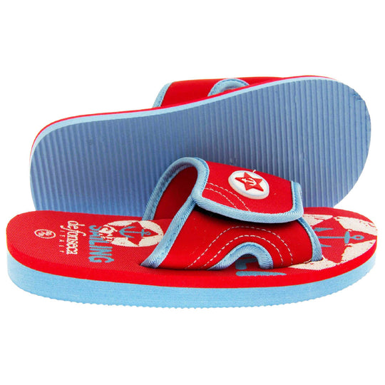 Kids slip on sandals. Slip on slider style sandals. Red touch fasten strap with light blue around the edge and a white synthetic circle in the centre of the strap with red anchor in the middle. The foam sole is two toned. The top half is red, the bottom half is pale blue. Both feet from side profile with left foot on its side to show the sole.