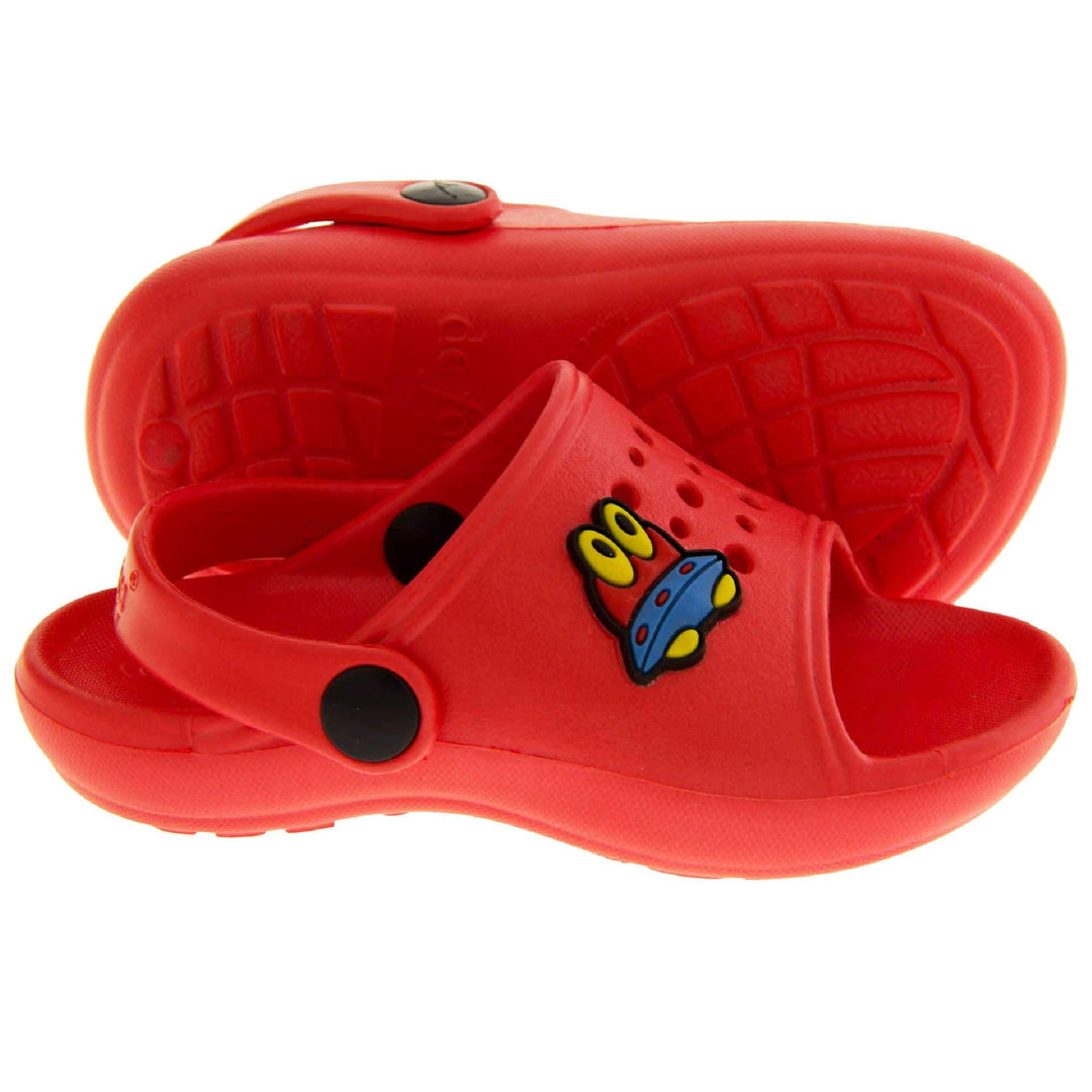 Kids Summer Clogs. Red synthetic clog style shoes. Open toed with cut out holes in the upper with alien detail just off centre. Red strap that goes along the back of your heel. The strap can be moved along the top of the shoe instead to make the shoe a mule. Left foot at an angle.  Both feet from side profile with left foot on its side to show the sole.
