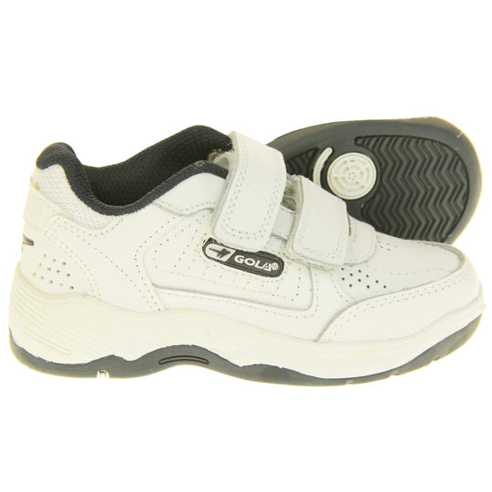 Kids trainers. White leather Gola trainers with fabric tongue. With Gola branding and logo on the side and two touch close straps. The lining is black textile. White chunky sole with black base. Both feet from side profile with left foot on its side to show the sole.