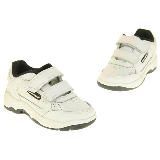 Kids trainers. White leather Gola trainers with fabric tongue. With Gola branding and logo on the side and two touch close straps. The lining is black textile. White chunky sole with black base. Both feet spaced apart in an V shape.