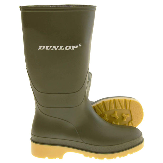 Kids Wellies. Green knee high wellies with a waterproof rubber upper and sole. With white Dunlop logo and brand on the side. Beige coloured rubber sole. Both feet from side profile with the left foot on its side to show the sole.
