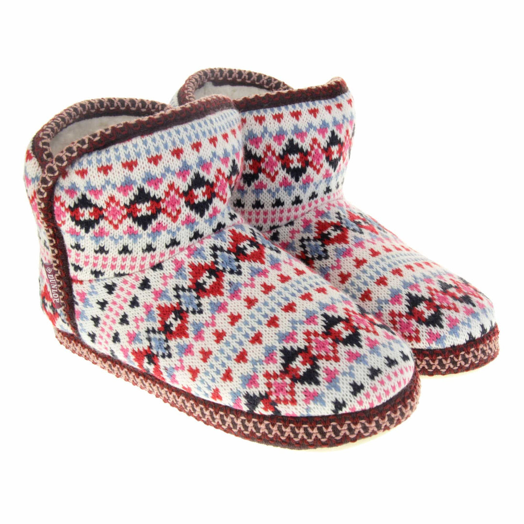Knitted boot slippers. Womens ankle boot style slippers with a white knit upper and multi coloured pattern in a Scandinavian Aztec style. Cream plush faux fur lining. Both feet together at angle.