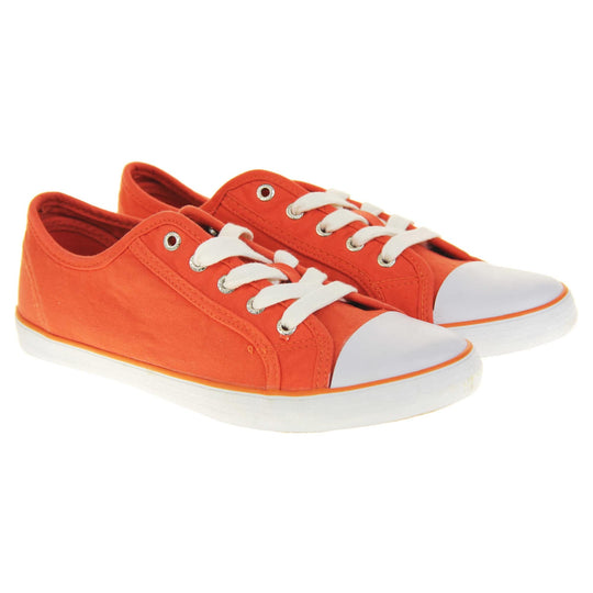 Lace up canvas sneakers. Women's shoes in a low top sneaker style with a orange canvas upper. White laces and white rubber toe bumper. Orange textile lining and white outsole with an orange line running around it and beige base. Both feet together at a slight angle.