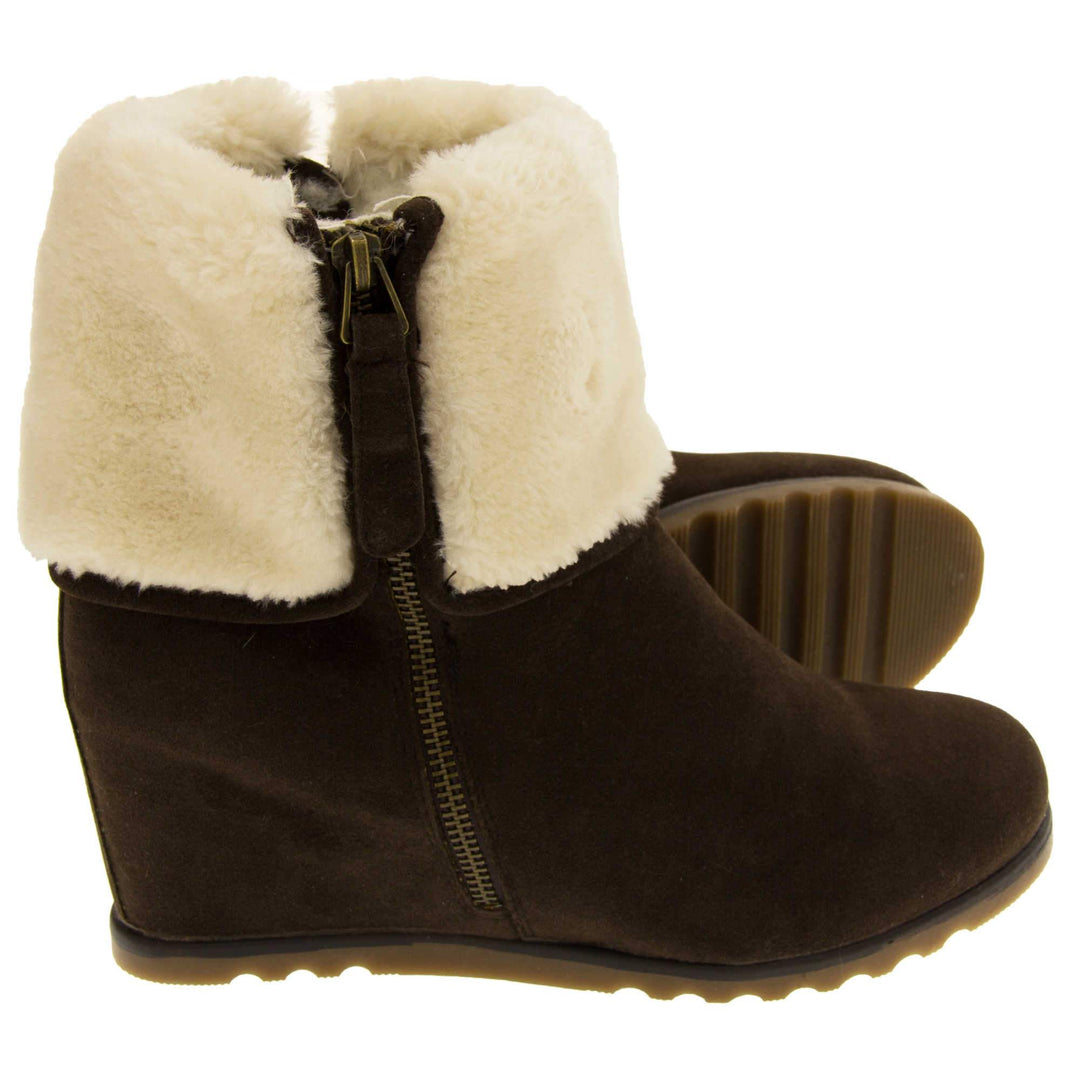 Ladies ankle boots. Dark brown faux suede wedge ankle boots. With zip fastening. Cream faux fur wide collar. Light brown sole with deep grip to the base. Both feet on a side profile with left foot on its side behind the right showing the sole.