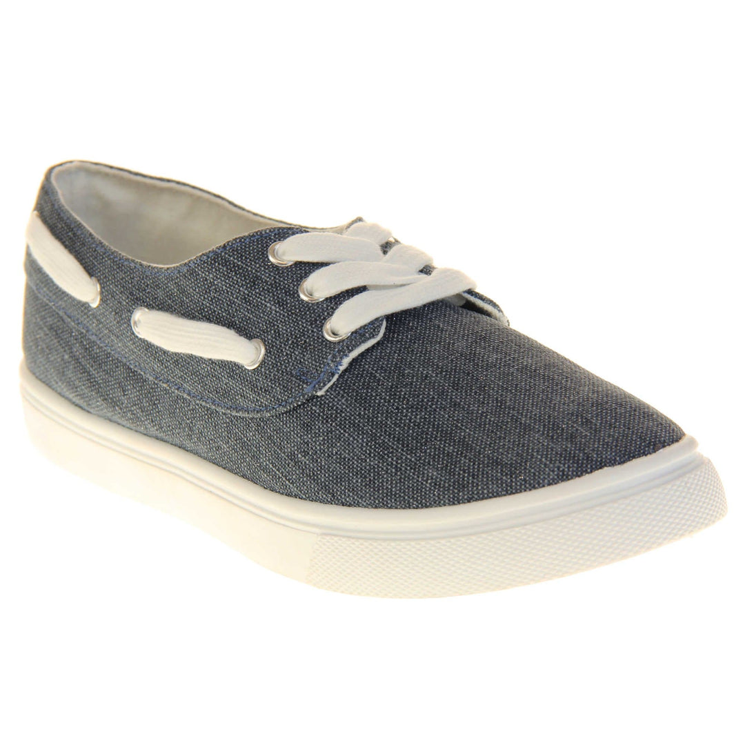 Ladies canvas slip on shoes. Sneaker style shoes with a navy blue canvas upper and white laces and white lace detailing around the outside of the collar. White outsole with slip-resistant grip to the bottom. Right foot at an angle.