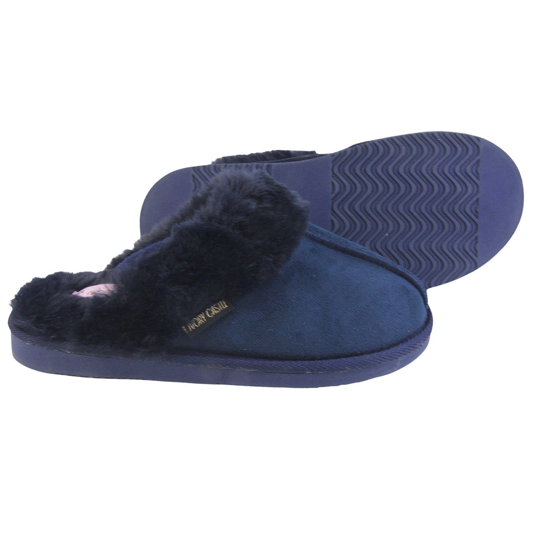 Ladies Faux Fur Mule Slippers. Slip on style slippers with Navy blue faux suede uppers. Navy faux fur lining and collar. Firm blue outsole with grip on the bottom. Both feet from a side profile with the left foot on its side behind the the right foot to show the sole.