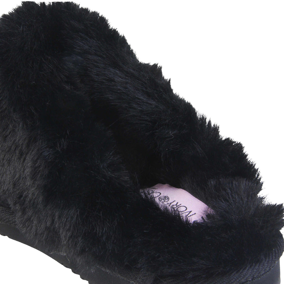 Ladies Memory Foam Slippers. Mule style slippers with black faux suede uppers. Black faux fur lining and collar. Firm black outsole with grip on the bottom. Close up of the fluffy lining and collar.