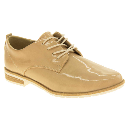 Ladies oxfords. Womens oxford style shoes with a beige patent faux leather upper. Stitching detail to the sides. Cream laces and beige lining. Brown and cream sole with a very slight heel. Right foot at an angle.