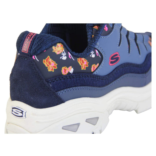 Blue Sketchers trainers with denim edging and a floral print. Lace up fastening with thick white soles.   close up on floral pattern view