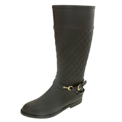 ladies wellies. Women's wellington boots in a knee length style. Black rubber upper with the leg done in a quilted effect. black rubber strap with buckle detail around the ankle. Black non slip sole. Left foot at an angle.