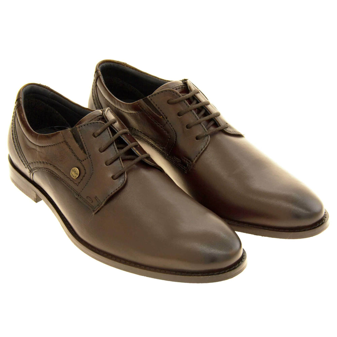 Leather dress shoes. Mens formal shoes with a brown leather upper and stitching detail. Brown laces to the front. Small gold stud on the side with S Oliver written on. Brown sole with very slight heel. Brown lining. Both shoes together from an angle.