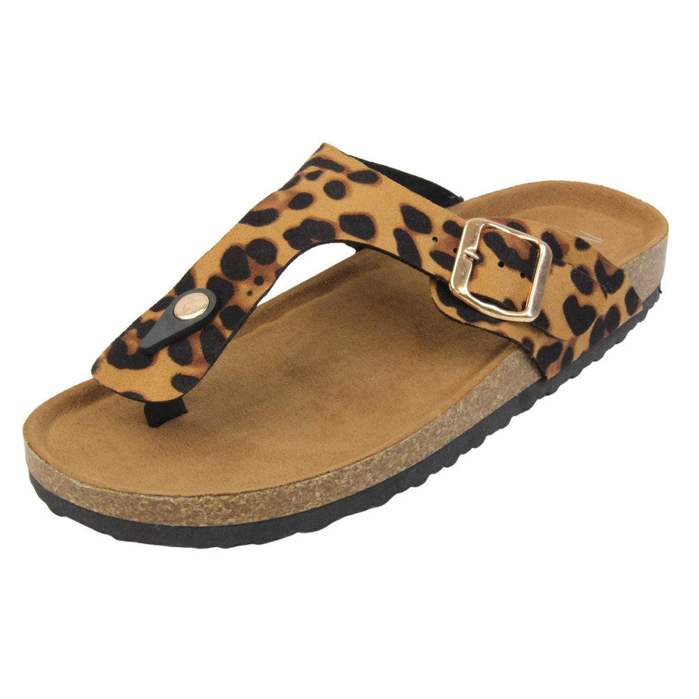 Leopard print flip flops. Leopard print faux suede strap with toe post to the front and gold buckle to the outside. Soft tan faux suede footbed with cork effect outsole and black sole. Left foot at an angle.