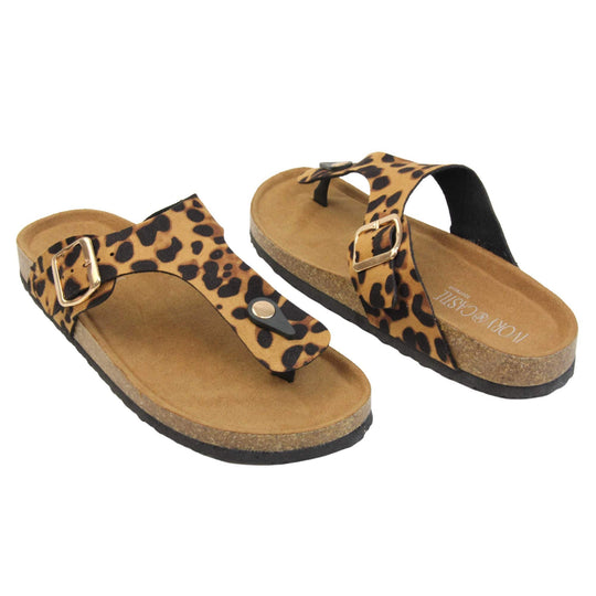 Leopard print flip flops. Leopard print faux suede strap with toe post to the front and gold buckle to the outside. Soft tan faux suede footbed with cork effect outsole and black sole.  Both feet at an angle facing top to tail.