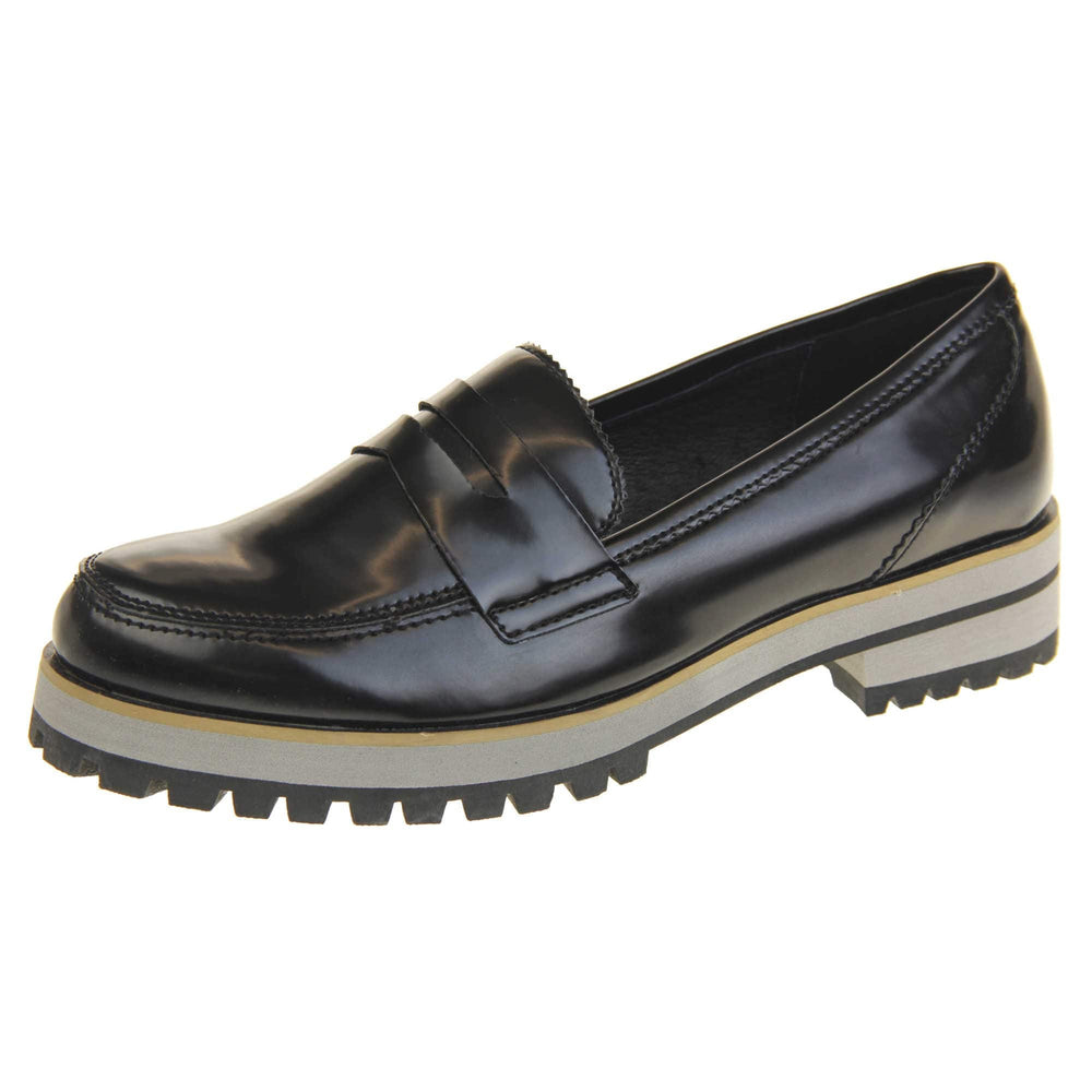 Loafer chunky sole. Loafer style shoes with a black faux leather upper. With a bar detail over the foot. Chunky black and grey sole with slip resistant grip to the bottom. Left foot at an angle.