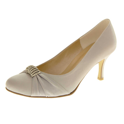 Low heel wedding shoe. Classic women's court shoe with a pale grey satin upper. Beige insole with Sabatine branding. Grey satin low stiletto heel with a cream sole. Diamante cluster and ruched detailing across the toes. Left foot at an angle.