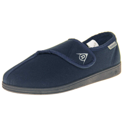Machine washable slippers. Full back slippers with a navy felt upper. Adjustable touch fasten strap to the top of the foot. Small grey label on the outside rim, with Dunlop branding in white. Navy textile lining. Firm black sole. Left foot at an angle.