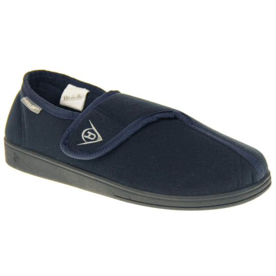 Machine washable slippers. Full back slippers with a navy felt upper. Adjustable touch fasten strap to the top of the foot. Small grey label on the outside rim, with Dunlop branding in white. Navy textile lining. Firm black sole. Right foot at an angle.