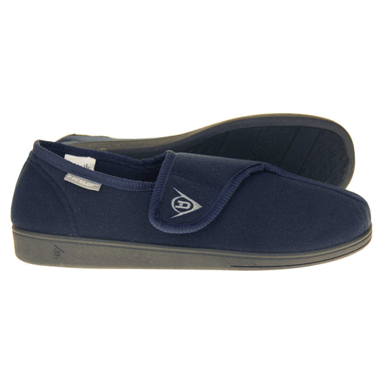 Machine washable slippers. Full back slippers with a navy felt upper. Adjustable touch fasten strap to the top of the foot. Small grey label on the outside rim, with Dunlop branding in white. Navy textile lining. Firm black sole. Both feet from side profile with left foot on its side to show the sole.