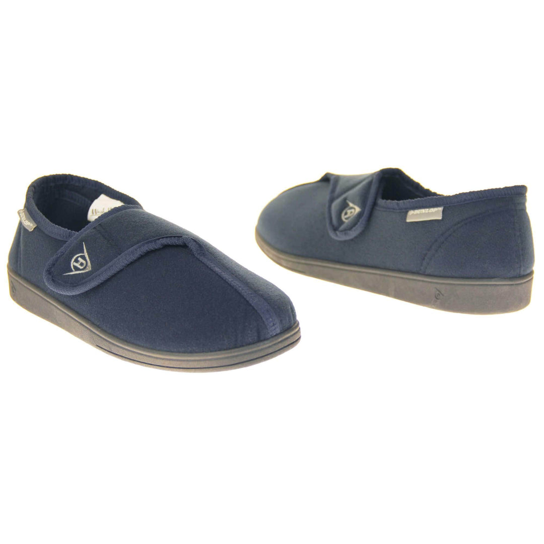 Machine washable slippers. Full back slippers with a navy felt upper. Adjustable touch fasten strap to the top of the foot. Small grey label on the outside rim, with Dunlop branding in white. Navy textile lining. Firm black sole. Both feet facing top to tail, at an angle.