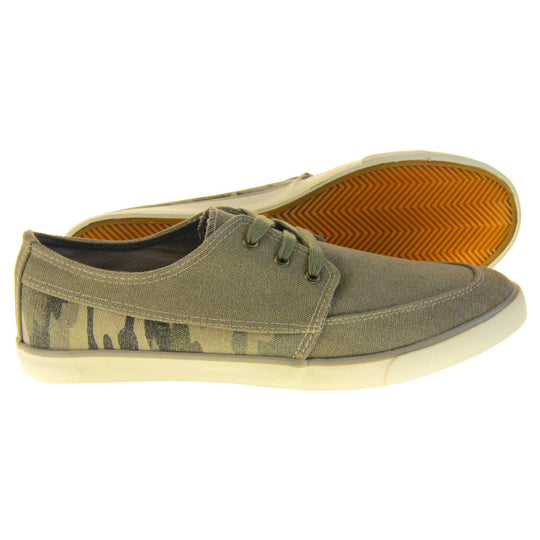 Mens camouflage trainers. Grey canvas upper with grey camo strip around the heel. Grey laces. White synthetic sole and dark textile lining. Both feet from a side profile with left foot behind the right on its side to show the sole.