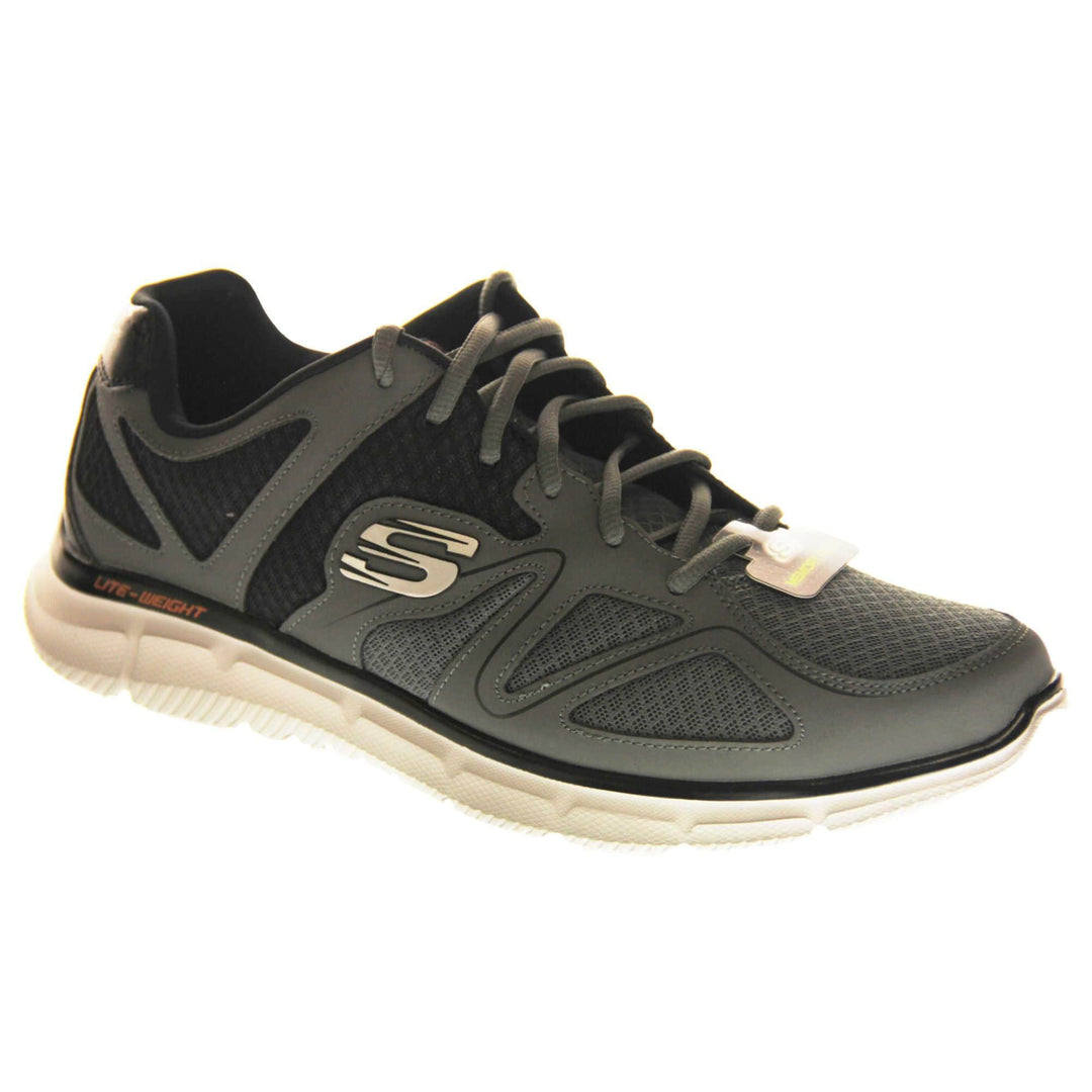 Mens grey Skechers. Charcoal grey mesh and leather upper with black elasticated laces for a slip on trainer. Black Skechers logo to the heel and chunky white outsole with grip. Right foot at an angle.