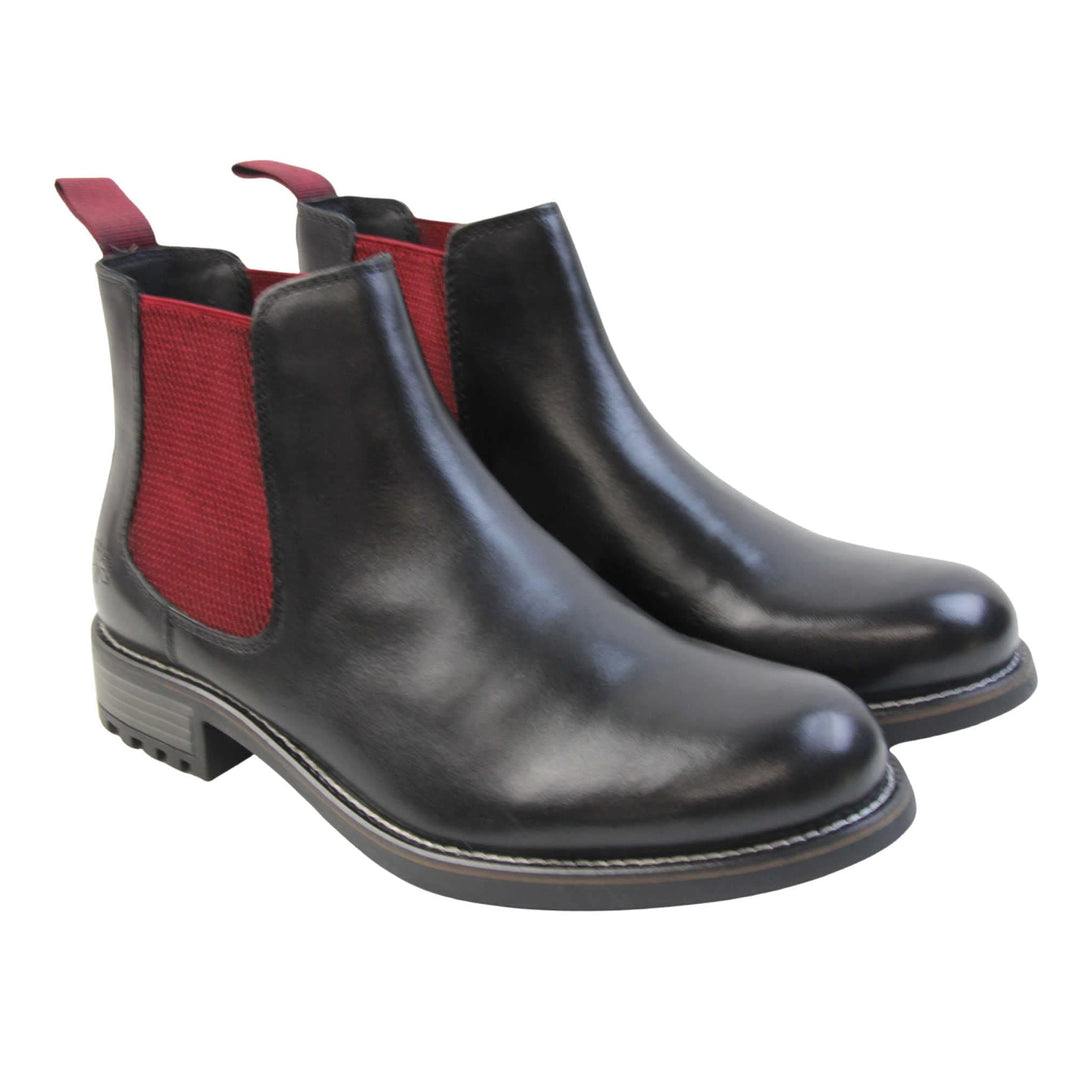 Mens leather Chelsea boots black. Ankle boots with black leather uppers and red textile elasticated side panels. Red textile tab to the back rim to help pull shoes on. Embossed Oakenwood brand to the outside heel of the boot. Black sole with very slight heel. Both feet together at a slight angle.