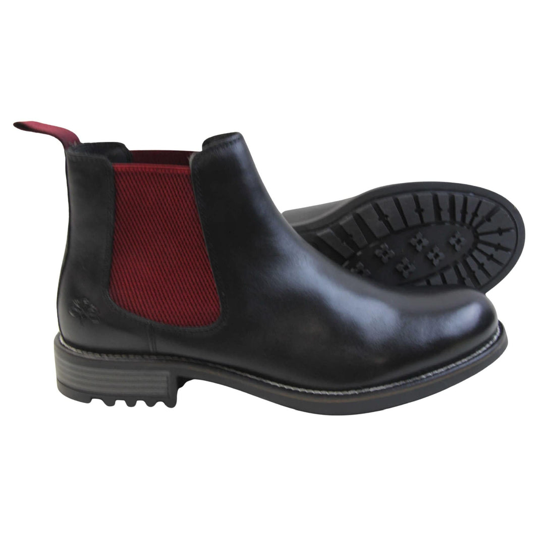 Mens leather Chelsea boots black. Ankle boots with black leather uppers and red textile elasticated side panels. Red textile tab to the back rim to help pull shoes on. Embossed Oakenwood brand to the outside heel of the boot. Black sole with very slight heel.  Both feet from a side profile with the left foot on its side behind the the right foot to show the sole.