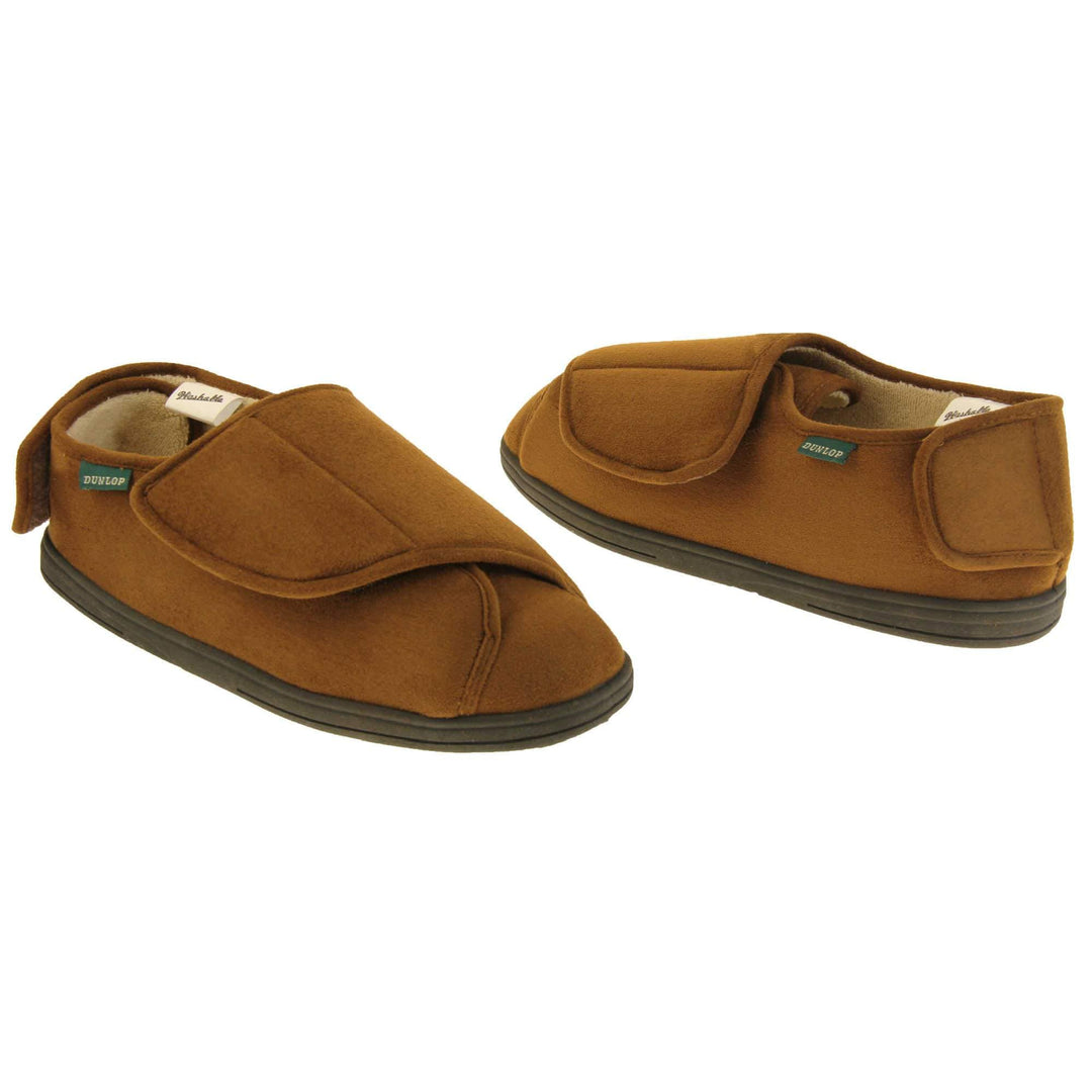 Mens adjustable slippers. Full back slippers with brown upper. Adjustable touch fasten strap to the top of the foot and around the back of the heel. Small white label on the outside rim, with Dunlop branding sewn in black. Cream faux fur lining. Firm black sole. Both feet facing top to tail, at an angle.