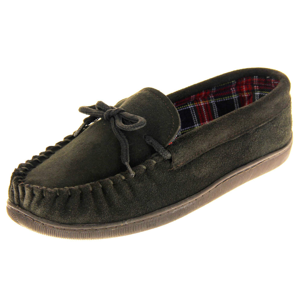 Mens plaid slippers. Moccasin style slipper with dark brown suede upper and leather bow to the top. Blue and red tartan plaid lining. Dark brown synthetic sole. Left foot at an angle.