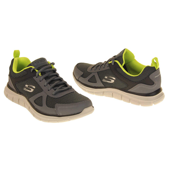 Mens Skechers sports trainers. Charcoal grey mesh and leather upper with grey laces and lime green lining. White Skechers logo to the side and chunky white outsole with black bottom with grip.  Both shoes at a slight angle facing top to tail.