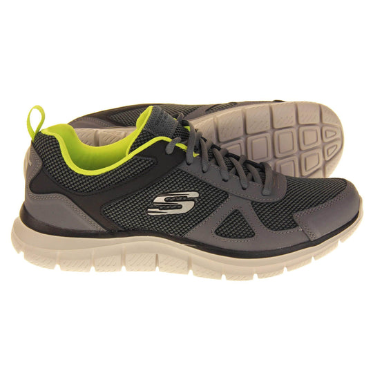 Mens Skechers sports trainers. Charcoal grey mesh and leather upper with grey laces and lime green lining. White Skechers logo to the side and chunky white outsole with black bottom with grip. Both feet from a side profile with the left foot on its side to show the sole.