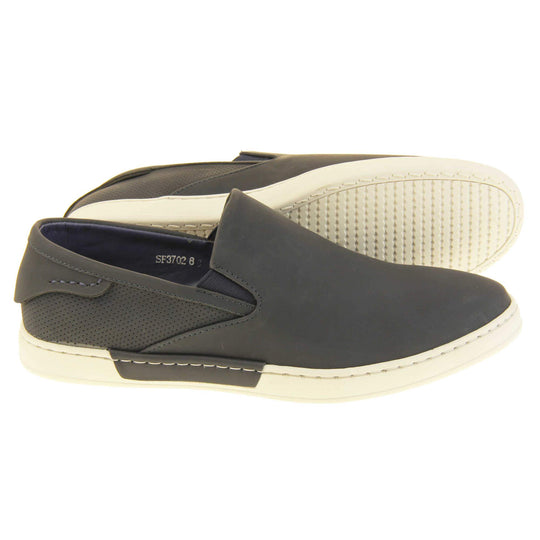 Mens slip on shoes. Black faux leather upper. White synthetic sole and dark textile lining. Both feet from a side profile with left foot behind the right on its side to show the sole.