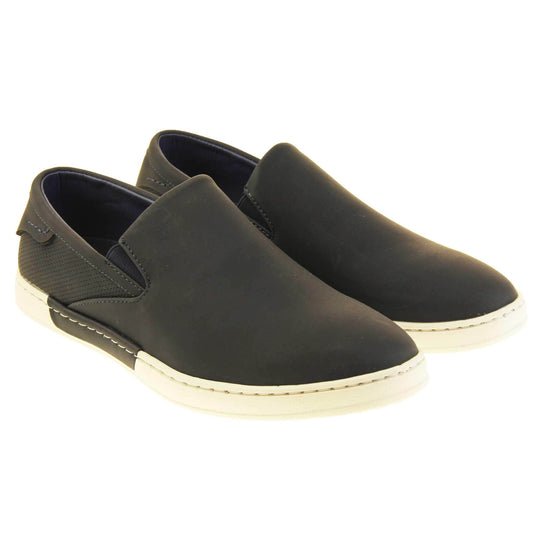 Mens slip on shoes. Black faux leather upper. White synthetic sole and dark textile lining. Both feet together at an angle.
