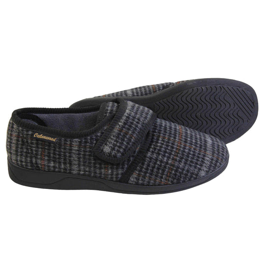 Mens adjustable slippers. Full back slippers with a black and grey check upper and black edging around the strap and collar of the shoe. Touch fasten strap across the bridge of the foot. Chunky black synthetic sole. Both feet from side profile with left foot on its side to show the sole.