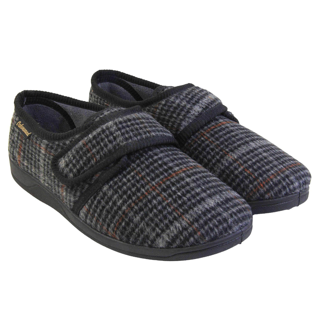 Mens adjustable slippers. Full back slippers with a black and grey check upper and black edging around the strap and collar of the shoe. Touch fasten strap across the bridge of the foot. Chunky black synthetic sole.  Both feet together from a slight angle.